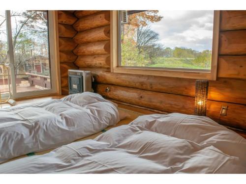 - 2 lits dans une chambre avec 2 fenêtres dans l'établissement Inaka no Kakurega Cottage Hideaway - Vacation STAY 19620v, à Inakadate