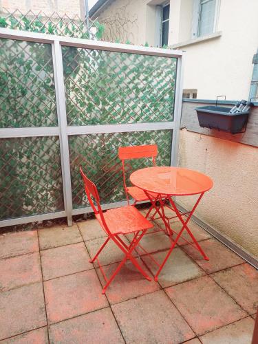菲雅克的住宿－Bienvenue à Figeac，露台上的红色桌子和红色椅子