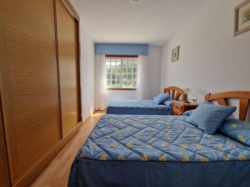 1 dormitorio con 2 camas y ventana en Apartamento cerca de la playa, en Pontevedra