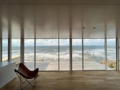 a chair in a room with a view of the ocean at Cliff House MORAI - Vacation STAY 14408 in Ishikari