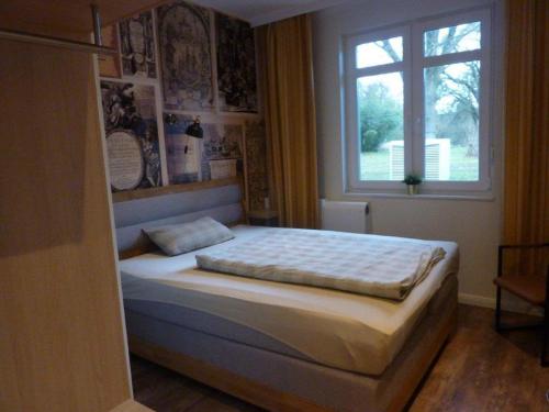 Bett in einem Schlafzimmer mit Fenster in der Unterkunft Niemann's Gasthof in Reinbek