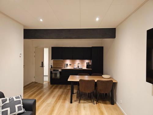 a kitchen and dining room with a table and chairs at New flat with hot tub - No2 in Oyndarfjørður