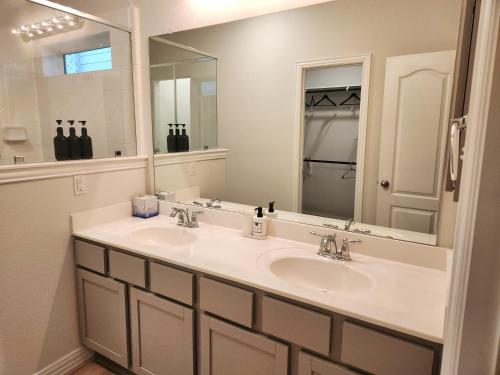 La salle de bains est pourvue de 2 lavabos et d'un grand miroir. dans l'établissement Anderson Lake Stays by ION Rentals near Downtown Med Center NRG Stadium Beltway 8, à Houston