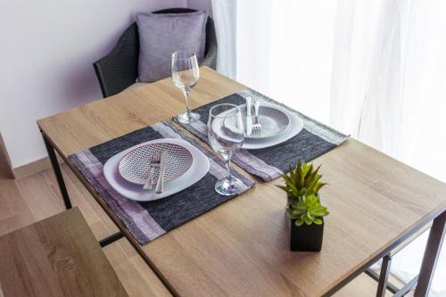 a wooden table with plates and wine glasses on it at Casa Villar in Alcalá del Júcar