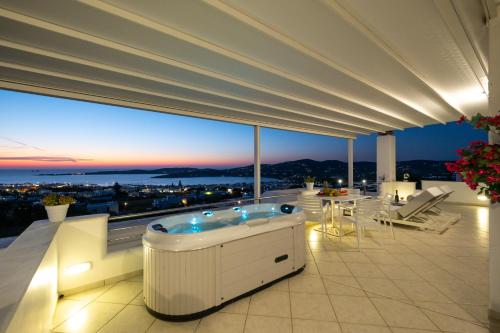 a jacuzzi tub on a balcony with a view at Panos Luxury Suite in Parikia