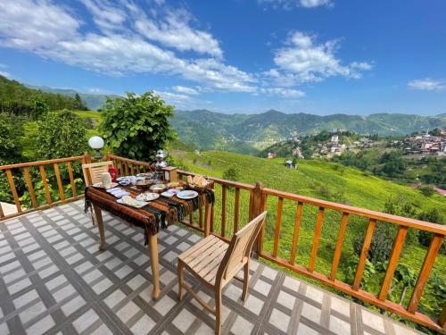 a table and chairs on a balcony with a view at Bungi dağ evleri in Rize