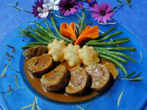 a plate of food with meat and vegetables on a blue plate at Kurhotel Würdinger Hof in Bad Füssing