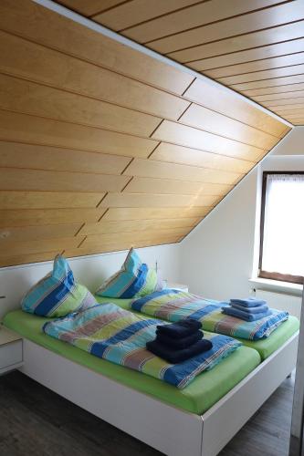 a bed in a room with a wooden ceiling at Ferienwohnung Wegmann in Borkum