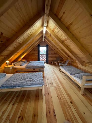 pokój z 3 łóżkami w drewnianym domku w obiekcie Urocze domki #1 w mieście Sitno