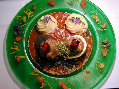 a green plate of food with meat and sauce at Kurhotel Würdinger Hof in Bad Füssing