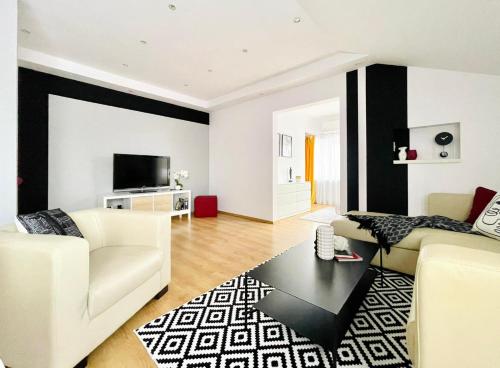 a living room with white furniture and black and white walls at R&B apartment in Timişoara