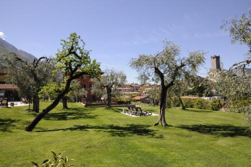 a park with trees and a bench in the grass at Casa Guarnati Lake View Apartments in Malcesine