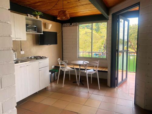 a kitchen with a table and chairs in a room at Ecolodge Bahia del Peñón in Guatapé