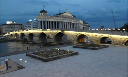 a bridge with a building in the city at night at Skopje Kale Luxury Apartment in Skopje