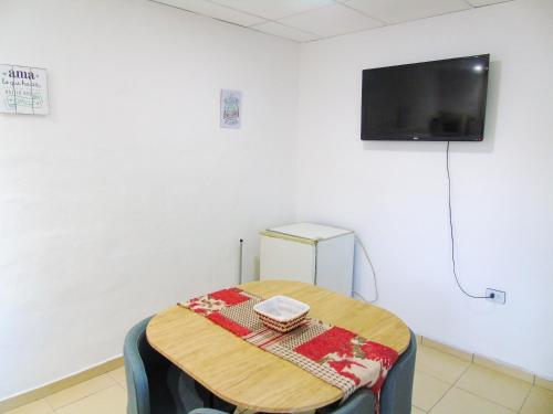 a room with a table and a tv on a wall at Comodo y Practico departamento in La Rioja