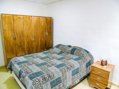 a bedroom with a bed and a wooden cabinet at Comodo y Practico departamento in La Rioja