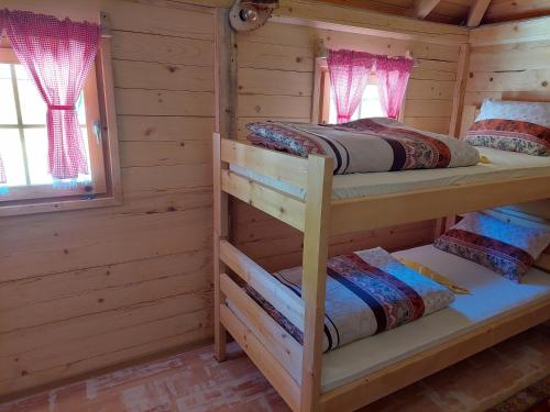 a bedroom with two bunk beds in a log cabin at Rafting Camp Konak in Foča