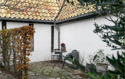 a patio with a chair and a table and a roof at 3 Bedroom Stunning Home In Simrishamn in Simrishamn