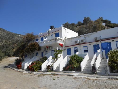 a white building with blue doors and stairs at Nikos Place in Agia Galini
