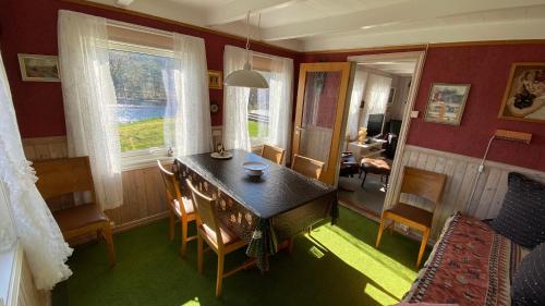 ein Esszimmer mit einem Tisch und Stühlen in einem Zimmer in der Unterkunft Hytte at Oyvoll in Farsund in Farsund