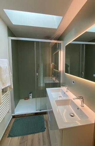 une salle de bain avec un lavabo et un miroir dans l'établissement La Villa Moon, à Lacanau-Océan