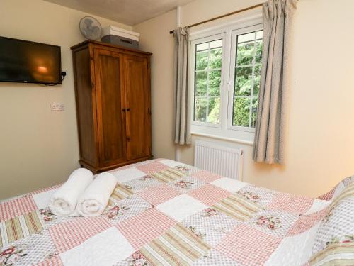 a bedroom with a bed with towels on it at Honeysuckle Cottage in Llandrindod Wells