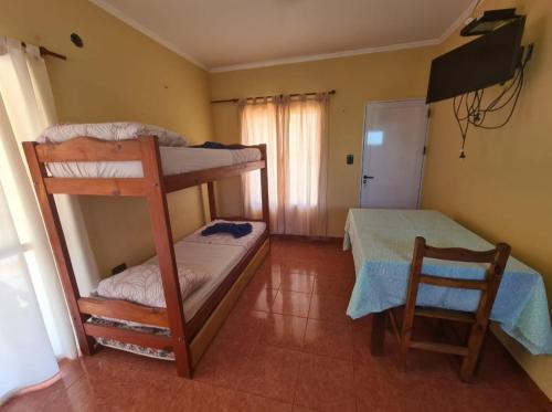 1 dormitorio con 2 literas y mesa en El Timbo en San José