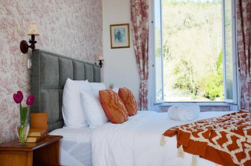 a bedroom with a white bed with a window at Valfrescos - Lac de Guerlédan in Caurel