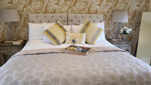 a bed with a tray with teddy bears on it at Brook Cottage in Kelling