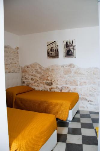two beds in a room with a checkered floor at Relais del Marchese in Turi