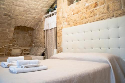 1 dormitorio con 2 camas y toallas. en Relais del Marchese, en Turi