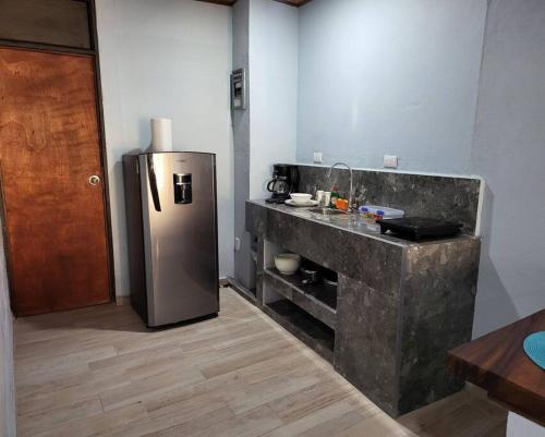 a kitchen with a stainless steel refrigerator in a room at MILA Apartments #4 in Tamarindo