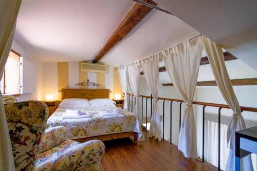 a bedroom with a bed and a chair in a room at Appartamento Borgo Apostoli in Florence