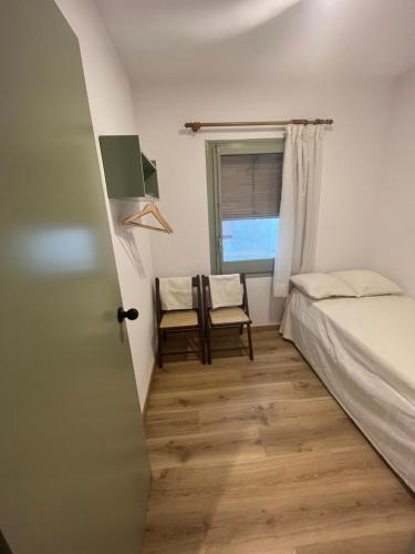 1 dormitorio con cama, ventana y silla en Racó de Mar, en Palamós