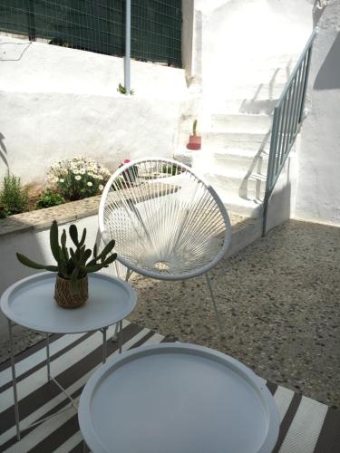 a patio with a white chair and a table at Cozy house with backyard at Iraklio Attikis in Athens