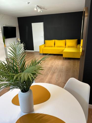 a living room with a yellow couch and a table at Apartamenty Avia - Energylandia Zator in Spytkowice
