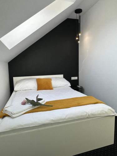 a bedroom with a white bed with a black wall at Apartamenty Avia - Energylandia Zator in Spytkowice