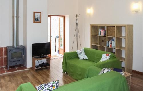 - un salon avec un canapé vert et une télévision dans l'établissement Cozy Home In Stetienne De Boulogne, à Saint-Étienne-de-Boulogne