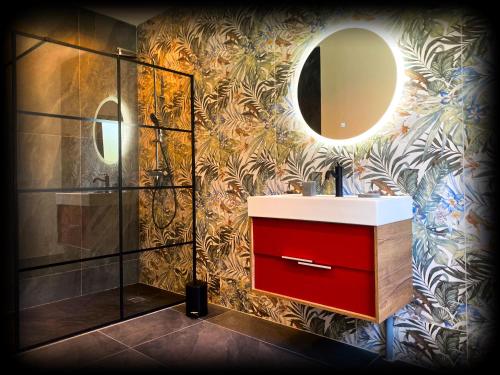 La salle de bains est pourvue d'une armoire rouge et d'un miroir. dans l'établissement VILLA Paolo, à Saint-Christol-lès-Alès