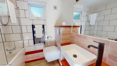 a bathroom with a sink and a tub and a toilet at 19 Strawberry Hill, Tolroy Manor in Hayle