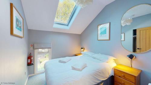 a bedroom with a large bed and a mirror at 19 Strawberry Hill, Tolroy Manor in Hayle