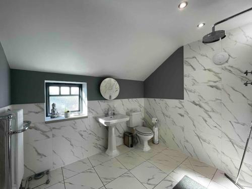 a bathroom with a sink toilet and a window at Luxury Barn Conversion Perfect for Family Getaways in Foggathorpe
