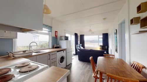 uma cozinha e sala de estar com uma mesa e uma sala de jantar em B44 Sea Urchin, Riviere Towans em Hayle