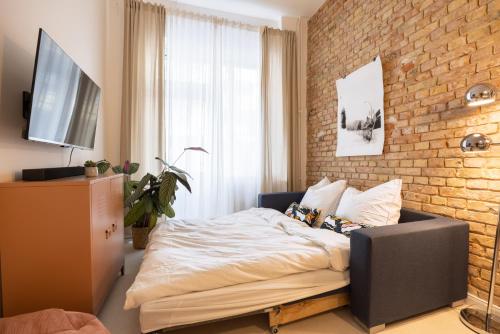 ein Schlafzimmer mit einem Bett und einer Ziegelwand in der Unterkunft Great 2-room apartment in Berlin