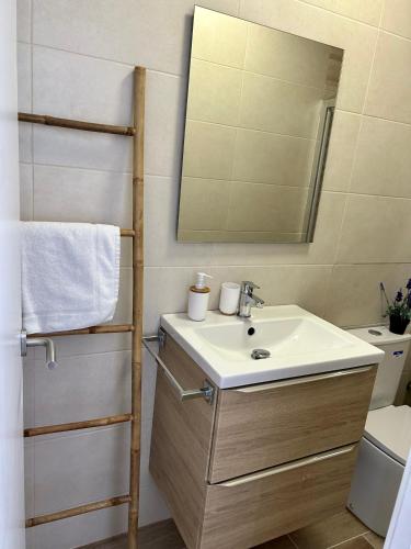a bathroom with a sink and a mirror and a toilet at Vilamarlux VII in Vilassar de Mar