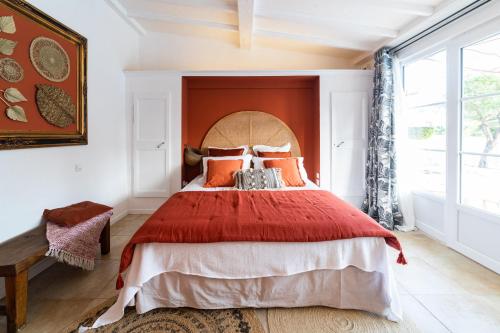 - une chambre avec un grand lit et un couvre-lit rouge dans l'établissement La Bastide du Mûrier, à Cotignac