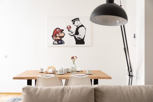 a dining room with a table and a painting on the wall at Apartments an der Oper - Innenstadt - Zentral - Küche - Wifi - Powered by Ko-Living in Halle an der Saale