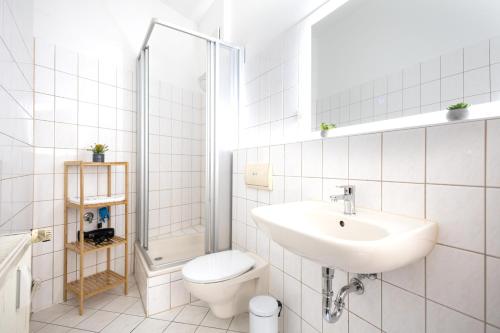 a white bathroom with a sink and a toilet at Apartments an der Oper - Innenstadt - Zentral - Küche - Wifi - Powered by Ko-Living in Halle an der Saale