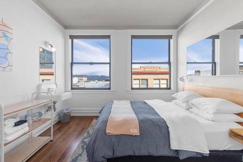 a bedroom with a large bed and two windows at Norblad Hotel in Astoria, Oregon