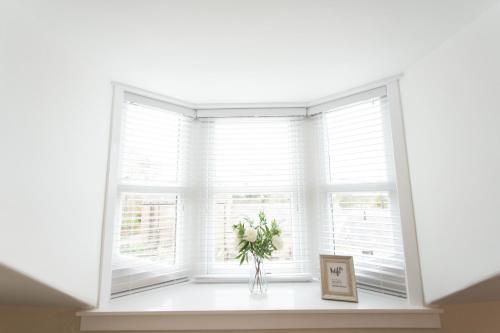 a window with a vase of flowers on a window sill at 4 Private bedroom house with 3 parking spaces free in Perth